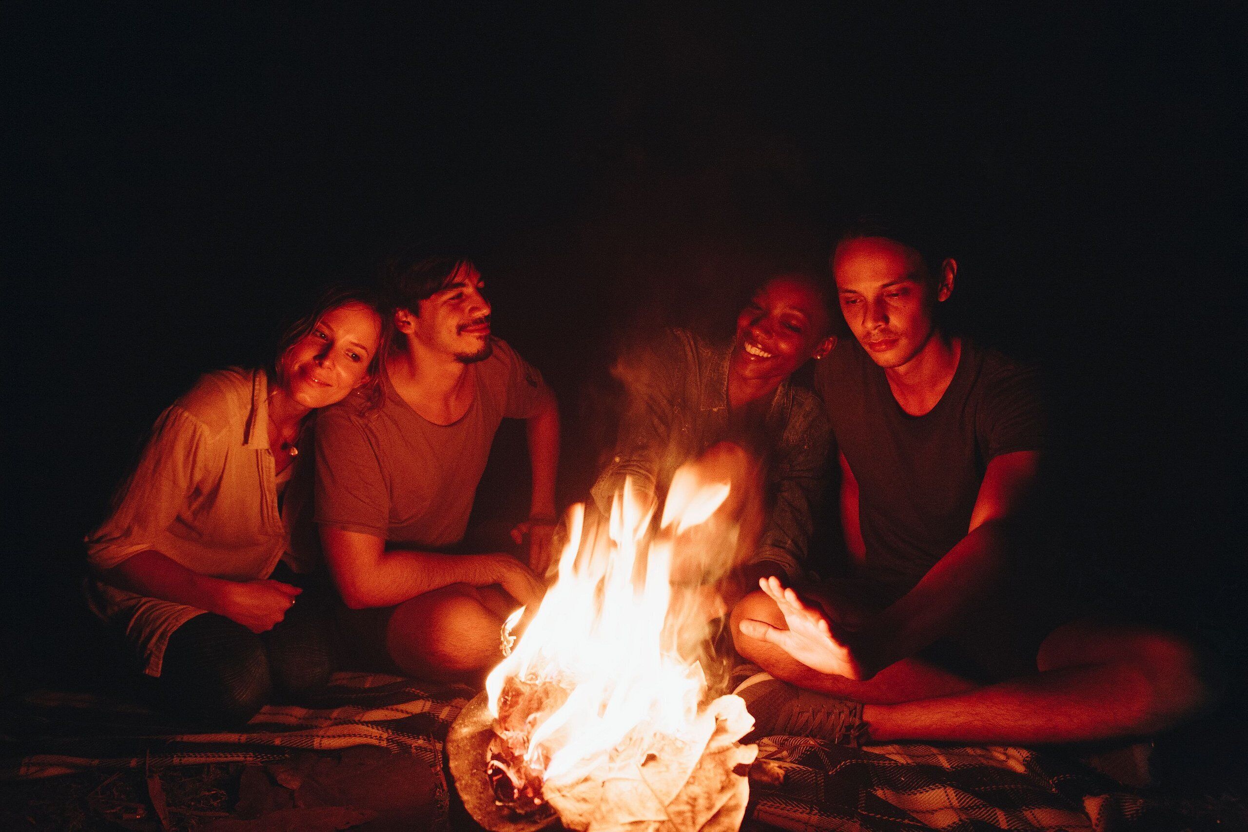 A group of people sitting around a campfire.