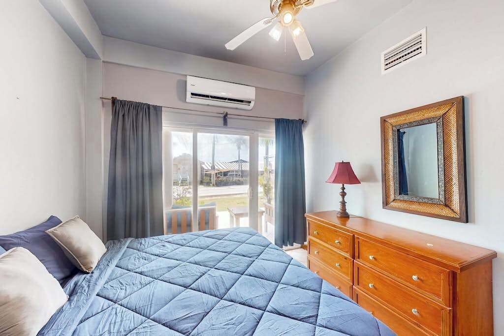 Ein Schlafzimmer mit Bett, Schminktisch, Spiegel und Klimaanlage.