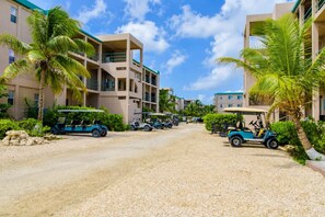 Ein Resort mit mehrstöckigen Gebäuden, einer Schotterauffahrt und Golfcarts, die an den Seiten geparkt sind.