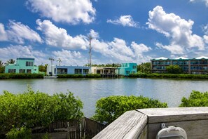 Ein Hotel am Wasser mit modernen Gebäuden, einem Steg und blauem Himmel.