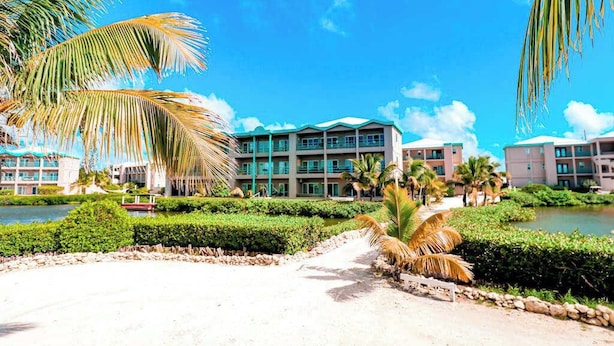 Ein Resort mit Strandbungalows, einem Pool und Palmen.