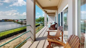 Ein Balkon mit Blick auf einen See, einem Sessel und einem Sofa.