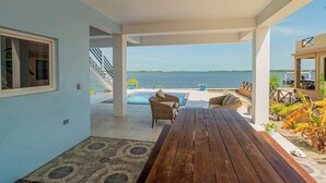 A covered outdoor area with a pool, seating, and a view of the sea. - Amazing 2 story oceanfront house with pool, balcony, central AC, & WD (San Pedro)