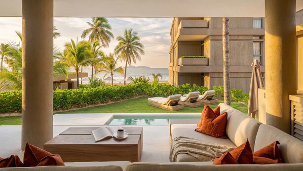 A poolside area with a sofa, lounge chairs, and a view of the ocean. - Anera | Private Oceanfront Garden (Playa Blanca)