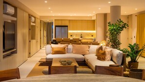 A modern living room with a sofa, coffee table, and television. - Anera | Private Oceanfront Garden (Playa Blanca)