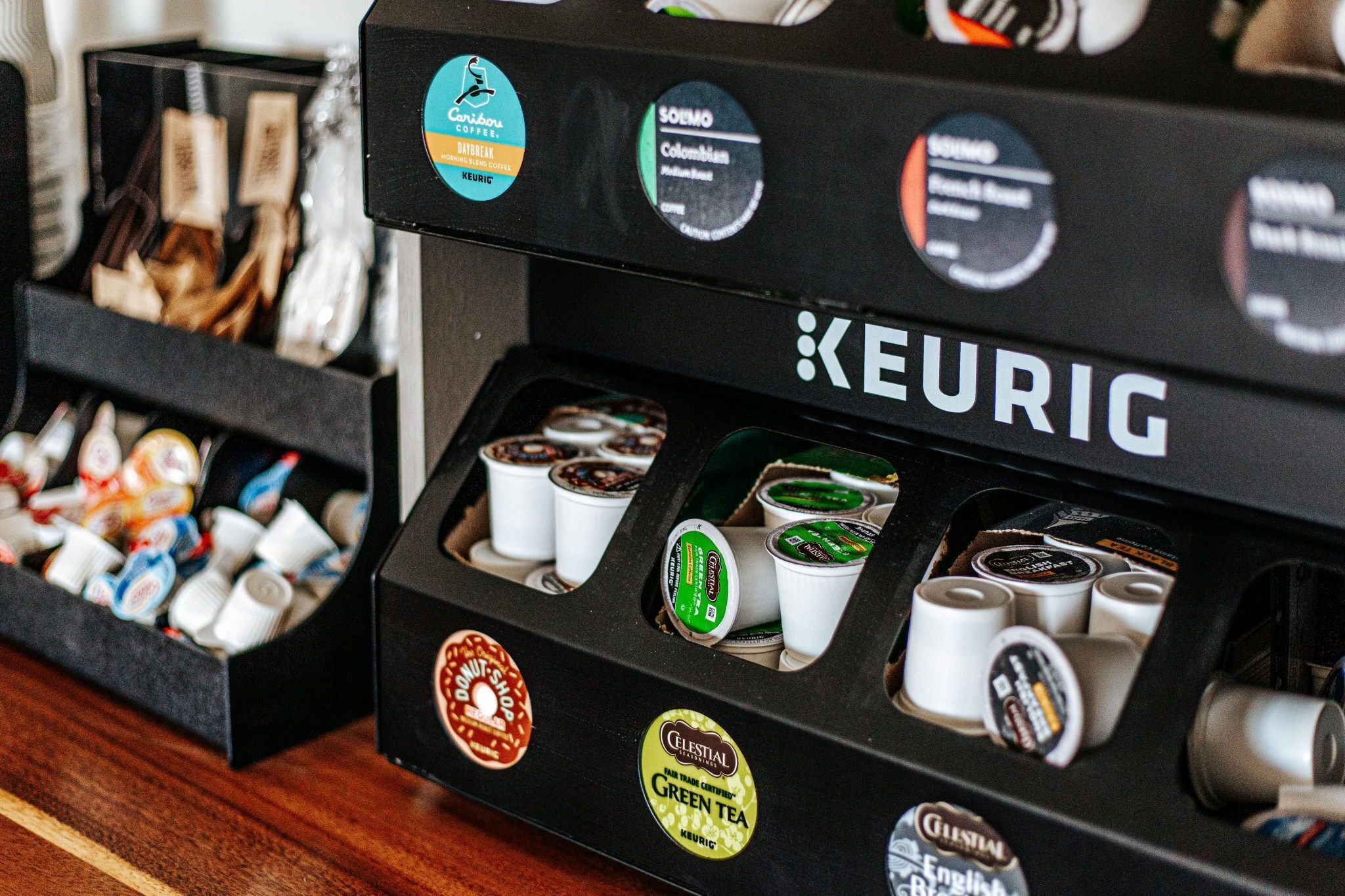 Una cafetera con varios tipos de cápsulas de café y una caja de cápsulas.