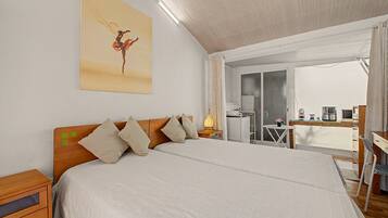 A bedroom with a large bed, a wooden headboard, and a painting on the wall.