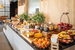 Buffet com diversos alimentos e seleção de frutas.