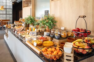 Un mostrador de buffet con diversos alimentos y una selección de frutas.