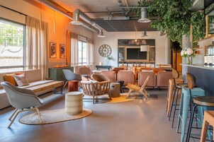 Una sala de estar moderna con un sofá, sillas, una mesa de centro y una chimenea.