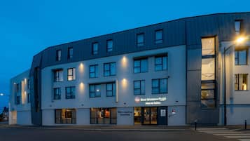Un moderno edificio de hotel con varios pisos, un bar y restaurante en la planta baja, y un letrero que indica 'Best Western PLUS' y 'Hotel de Robien'.