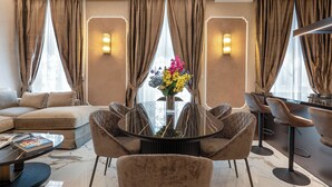 Una habitación de hotel moderna con un sofá, una mesa redonda de comedor y sillas.