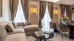 Una sala moderna con sofá, sillas, una mesa de centro y un comedor con un jarrón de flores.