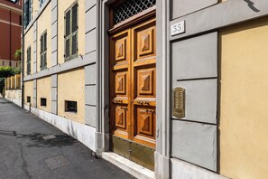 Ein Gebäude mit einer großen Holztür, einem Schild mit der Nummer 35 und einem Metalllüftungsgitter an der Wand.