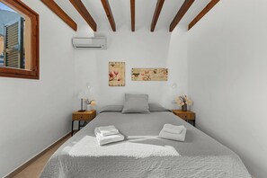 A bedroom with a bed, two nightstands, a window, and wall art. - Can Mayol, beautiful, newly refurbished village house at few steps from centre. (Fornalutx)
