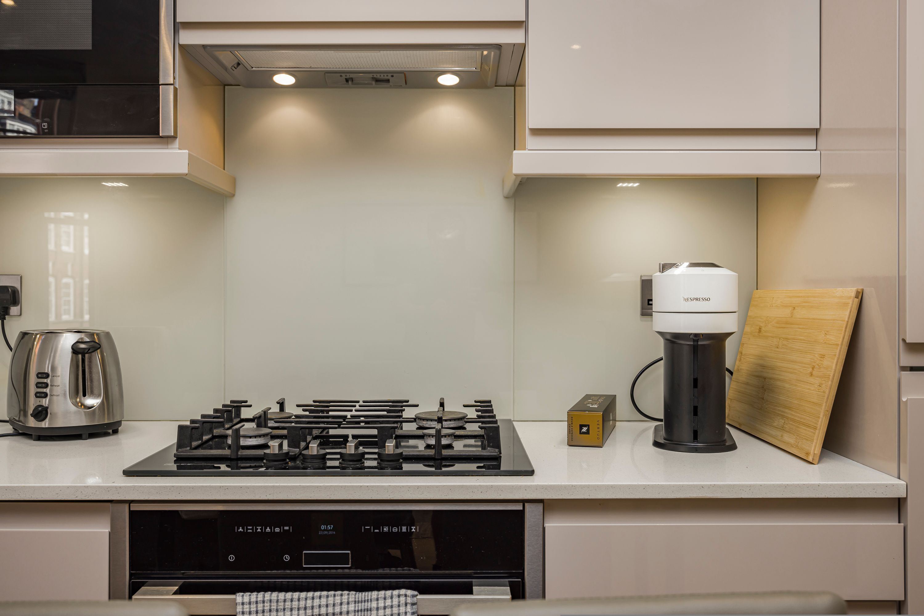 A modern kitchen with a gas stove, a coffee maker, and a toaster.