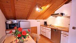 Cocina con armarios de madera, estufa, fregadero y refrigerador.