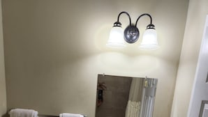 A small bathroom with a toilet, sink, and two wall-mounted light fixtures.