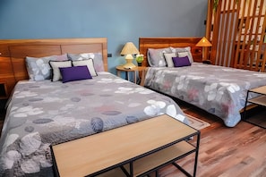 Una habitación de hotel con dos camas, una mesita y una lámpara en la mesita de noche.
