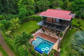 A two-story house with a red-tiled roof, a swimming pool, and a patio area. - Hotel Ecopaisajes Lake Premier Resort (Santa Rita)