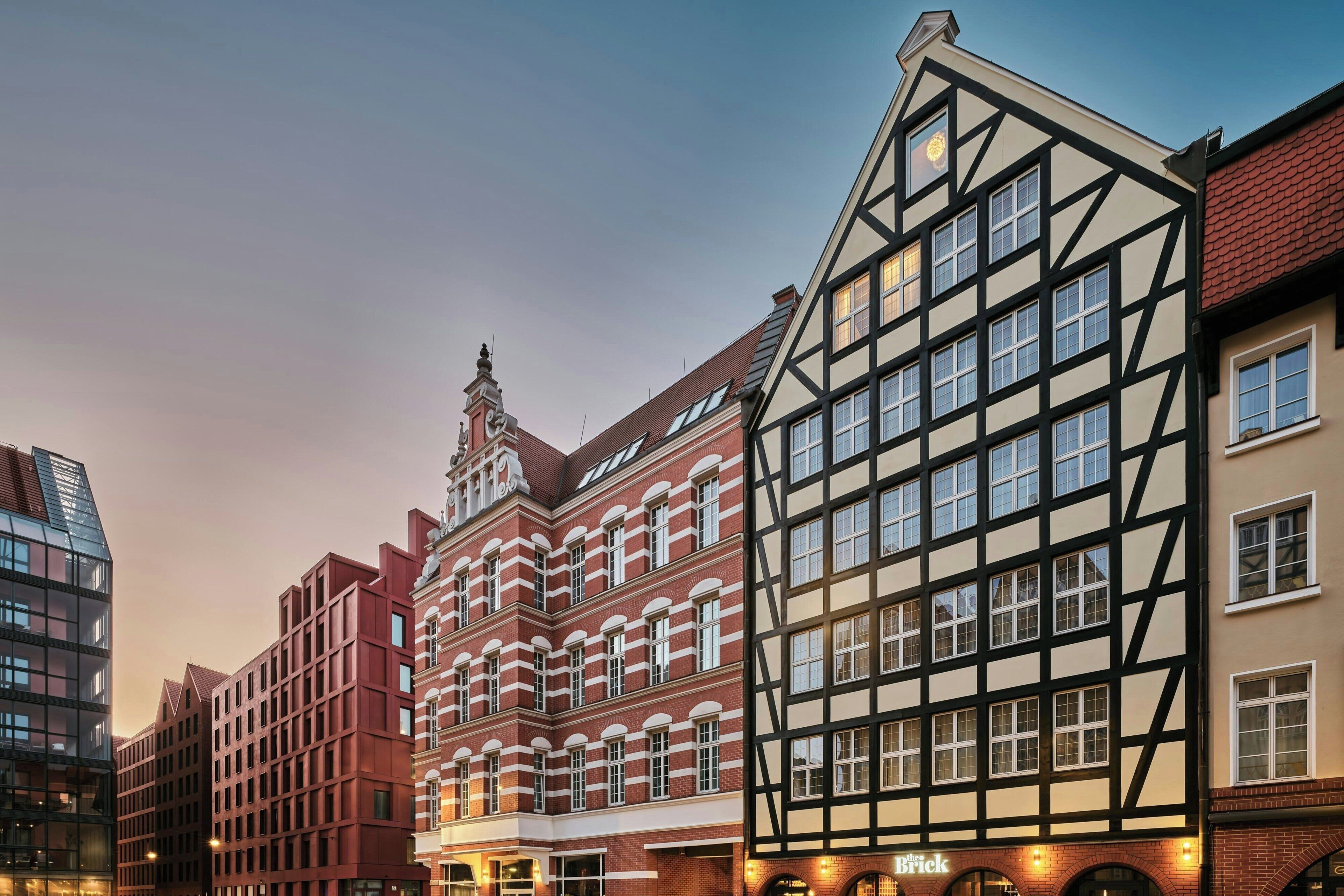 Una hilera de edificios tradicionales con entramado de madera junto a una estructura moderna de vidrio.