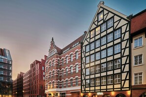 A row of traditional half-timbered buildings with a modern glass structure adjacent to them. - The Brick, a Tribute Portfolio Hotel - Adults Only (Gdansk)
