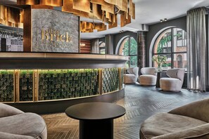 A modern lobby with a reception desk, seating area, and large windows. - The Brick, a Tribute Portfolio Hotel - Adults Only (Gdansk)