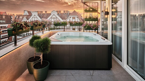 A rooftop terrace with a hot tub, potted plants, and a city view at sunset. - The Brick, a Tribute Portfolio Hotel - Adults Only (Gdansk)