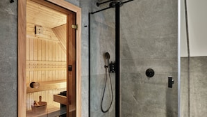 A modern bathroom with a glass-enclosed shower, a wooden sauna, and a minimalist design. - The Brick, a Tribute Portfolio Hotel - Adults Only (Gdansk)