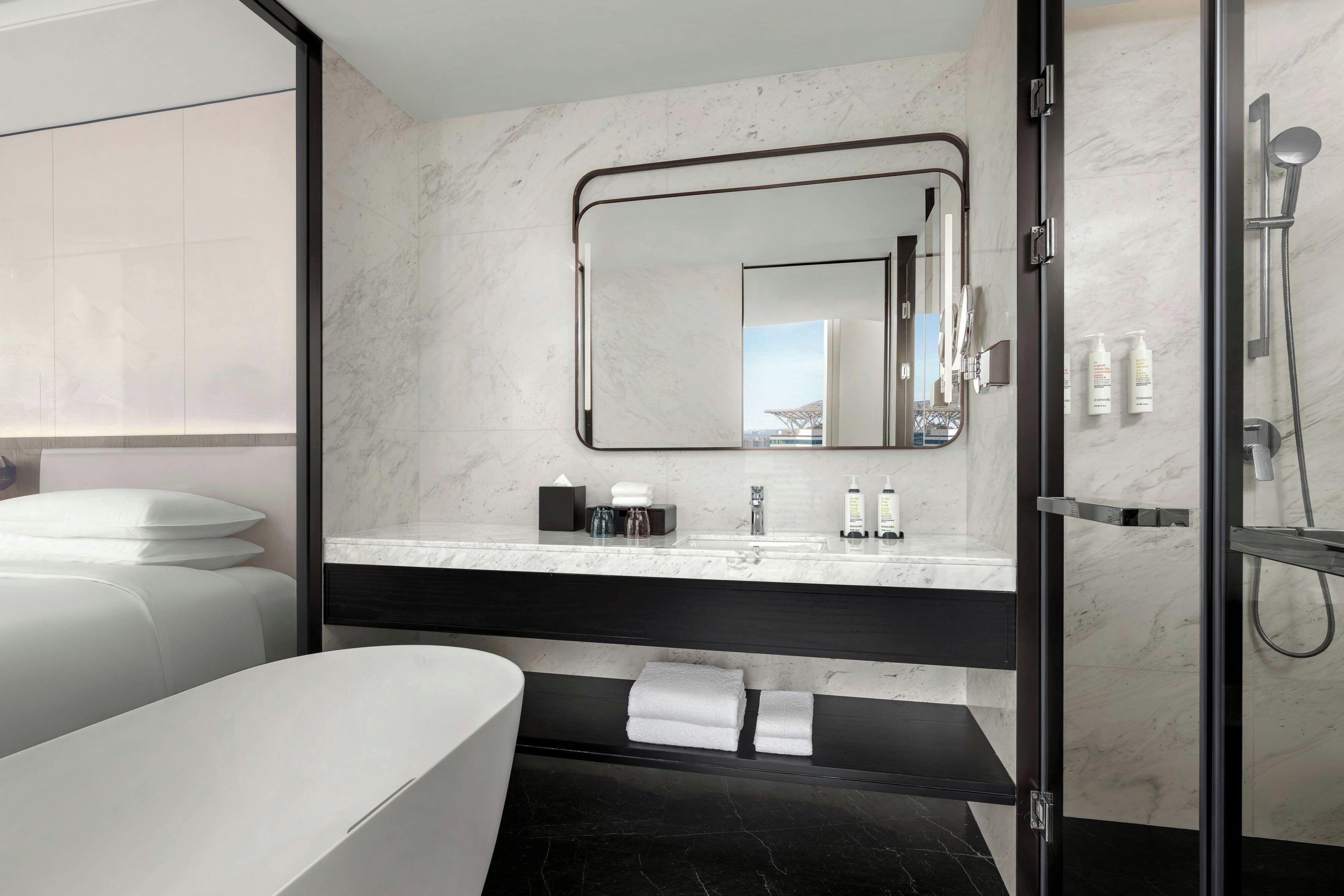 Un baño moderno con un espejo grande, ducha y bañera.