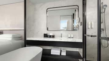 Un baño moderno con un espejo grande, ducha y bañera.