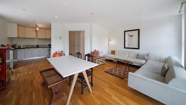 A modern living space with a dining table, sofa, and kitchen area. - Regent's Canal View Apartment (London)