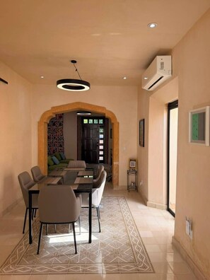 A dining area with a glass table, chairs, and a patterned rug. - Ciricote House (Centro)
