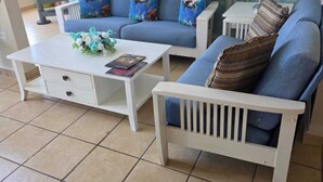 A living room with a blue sofa, white coffee table, and a patterned wall. - Paradise Penthouse at Aquatika Loiza (Vieques)