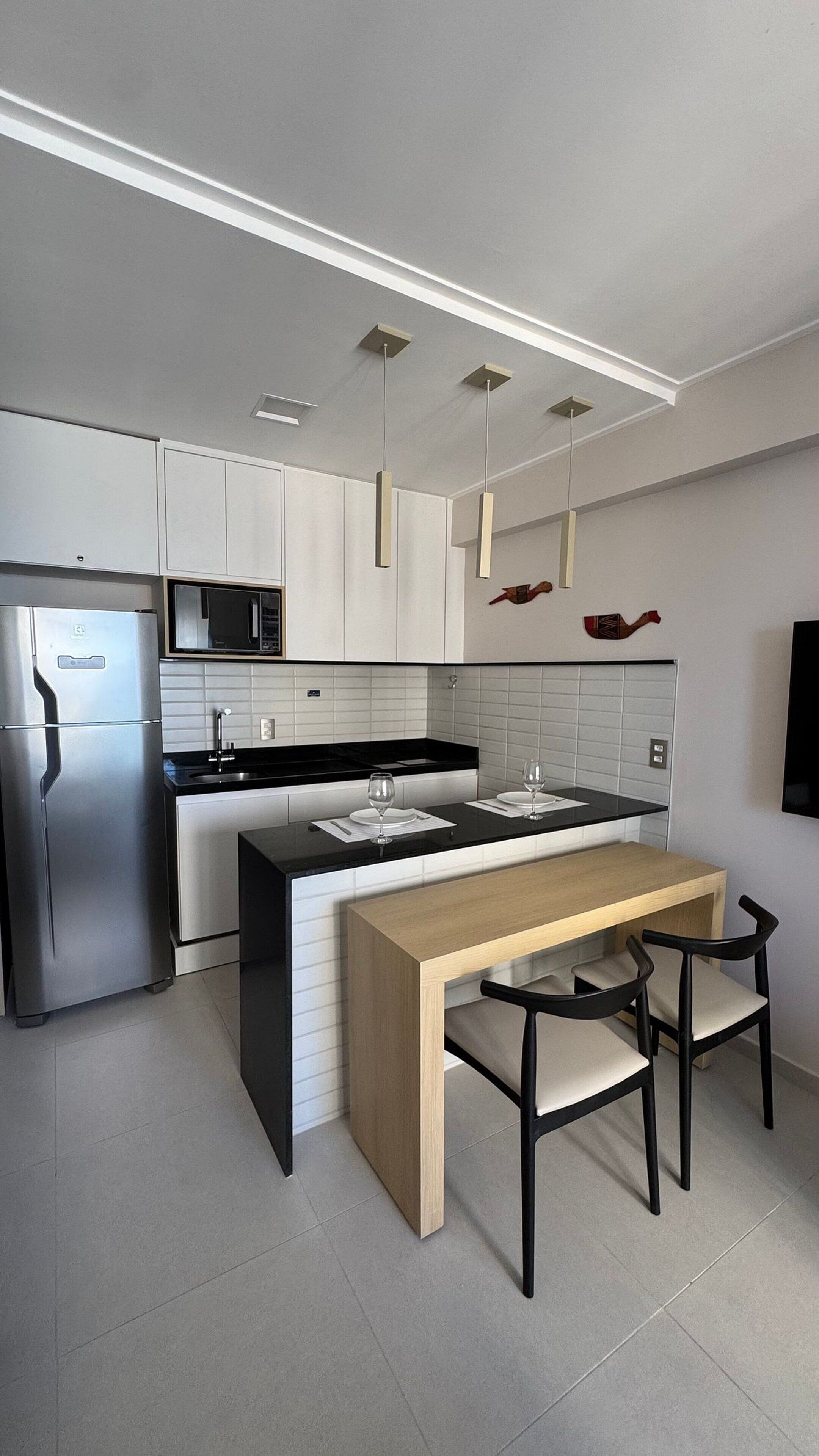 A modern kitchen with a central island, stainless steel appliances, and pendant lighting.