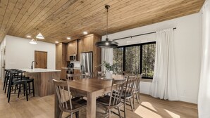 Eine moderne Küche mit Holzschränken, einer zentralen Kochinsel und einem Essbereich mit Holzkästen.