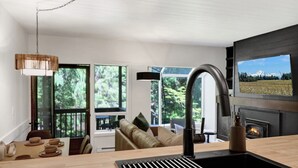 A modern kitchen with a large window, a fireplace, and a view of a mountain.