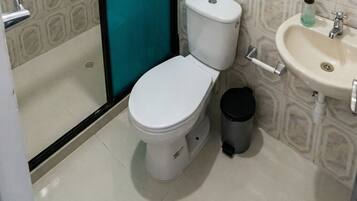 Regadera, secadora de cabello, toallas, papel de baño