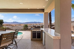 An outdoor patio with a pool, a grill, and a view of mountains. - Mountain Vista Hideaway by J and Amy BL 992768 (Mesquite)