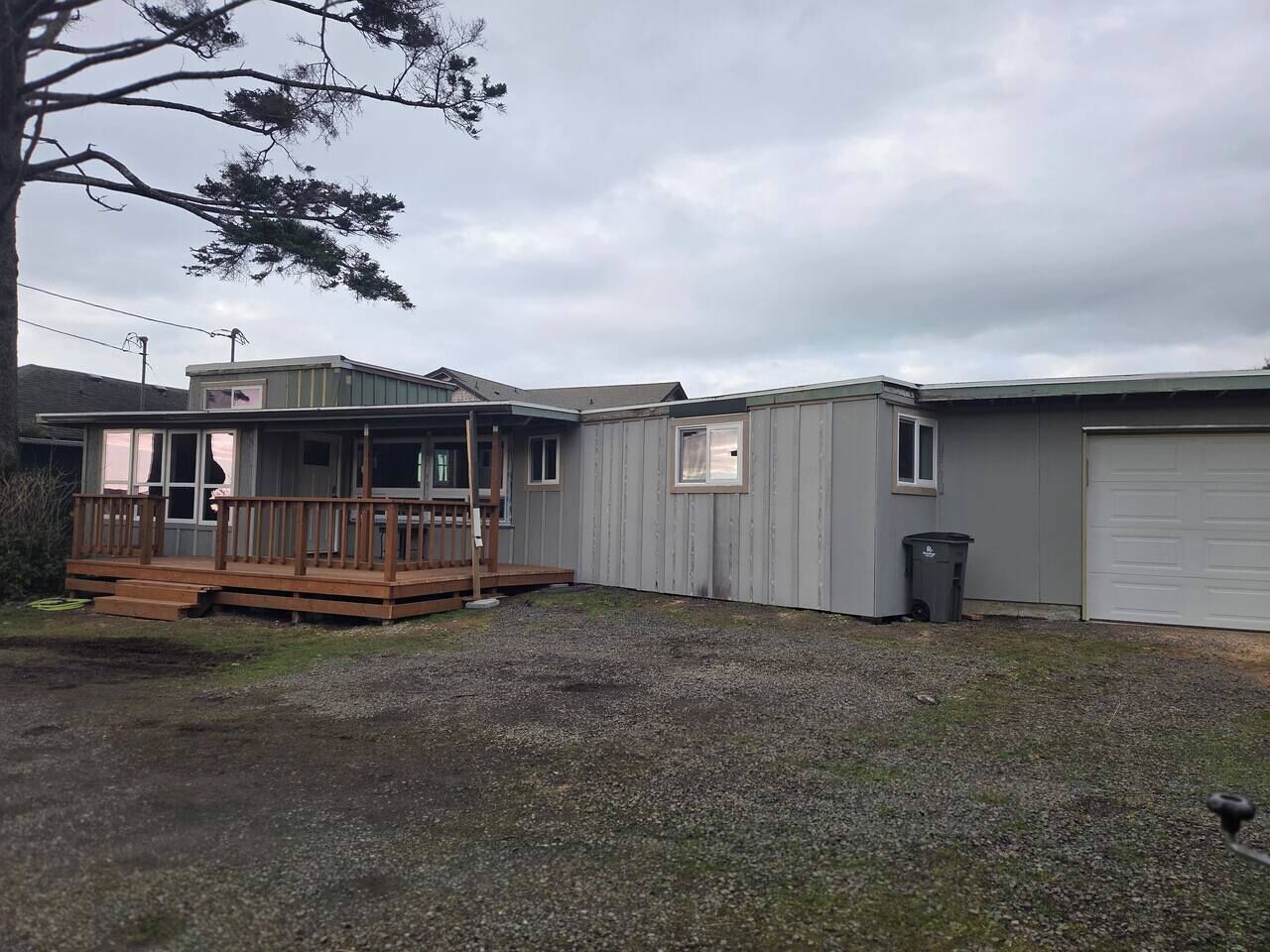 A residential property with a wooden deck, a garage, and a fenced yard.