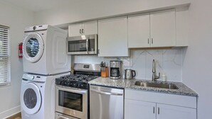 A compact kitchen with a washing machine, microwave, stove, oven, and sink. - Dormont, Potomac @3 Stylish and Cozy 2 Bedroom Private Apartment (Pittsburgh)
