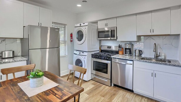 A compact kitchen with a refrigerator, microwave, stove, oven, and washing machine. - Dormont, Potomac @3 Stylish and Cozy 2 Bedroom Private Apartment (Pittsburgh)