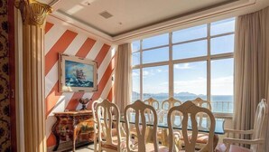 A room with a large window, a painting, and a table with chairs. - Apartment With sea View in RJ Brt1001 (Rio de Janeiro)