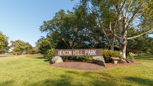 Schild für den Beacon Hill Park, mit einer Wiese und Bäumen.