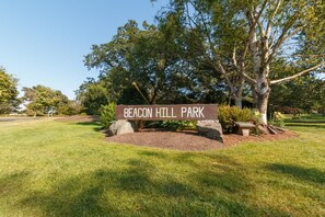 Schild für den Beacon Hill Park, mit einer Wiese und Bäumen.