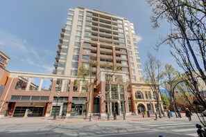 A multi-story hotel with a modern architectural design, featuring a prominent entrance with a glass facade and a parking garage below.
