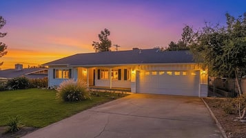 A single-story house with a garage, a driveway, and a well-maintained lawn.