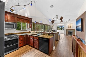 A modern kitchen with built-in appliances, wooden cabinetry, and a large island. - 601 Monroe Ave (Cape Canaveral)