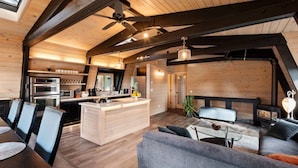 A modern loft-style interior with a kitchen, dining area, and seating space. - Tahoe Sanctuary | Hot Tub Sauna | Mountain & Lake Views | Air Conditioning (South Lake Tahoe)