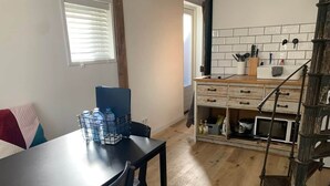 Et køkken med træskabe, en mikrobølgeovn og en vanddispenser på bordet.